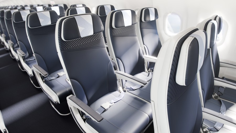 Interior view of an airplane seating layout with modern passenger seats featuring a sleek design and adjustable headrests.