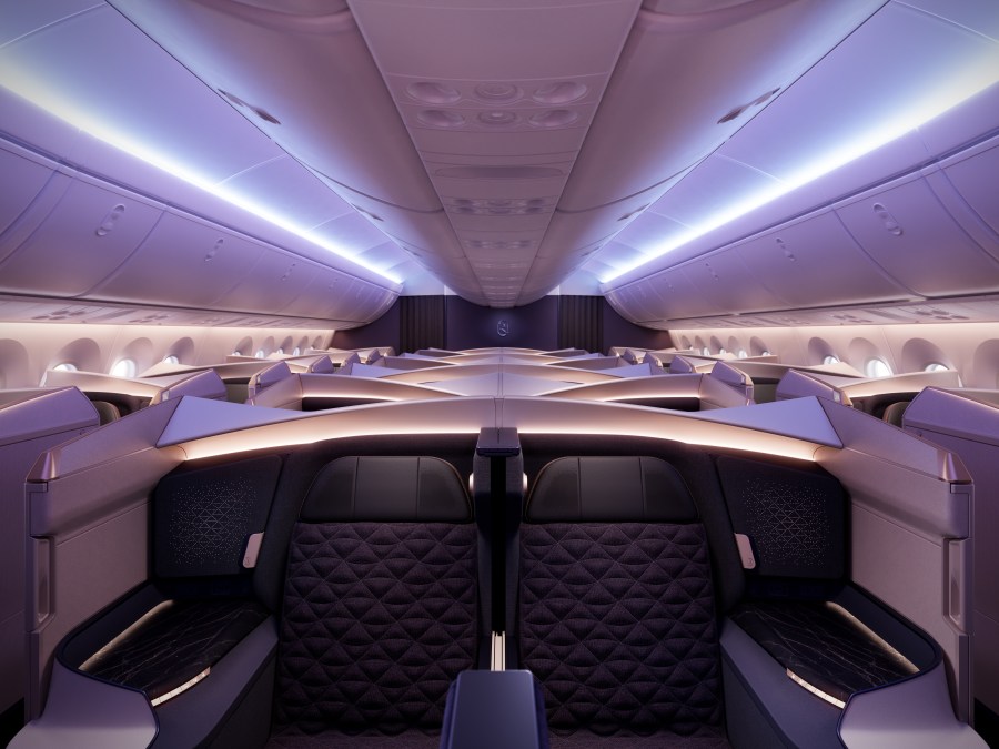 Interior view of a modern airplane cabin showcasing stylish seating and ambient lighting
