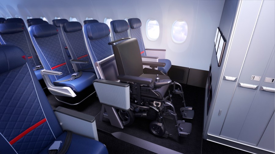 An interior view of an airplane showcasing a specially designed space for a wheelchair, with adjacent passenger seats and an overhead cabin storage area.