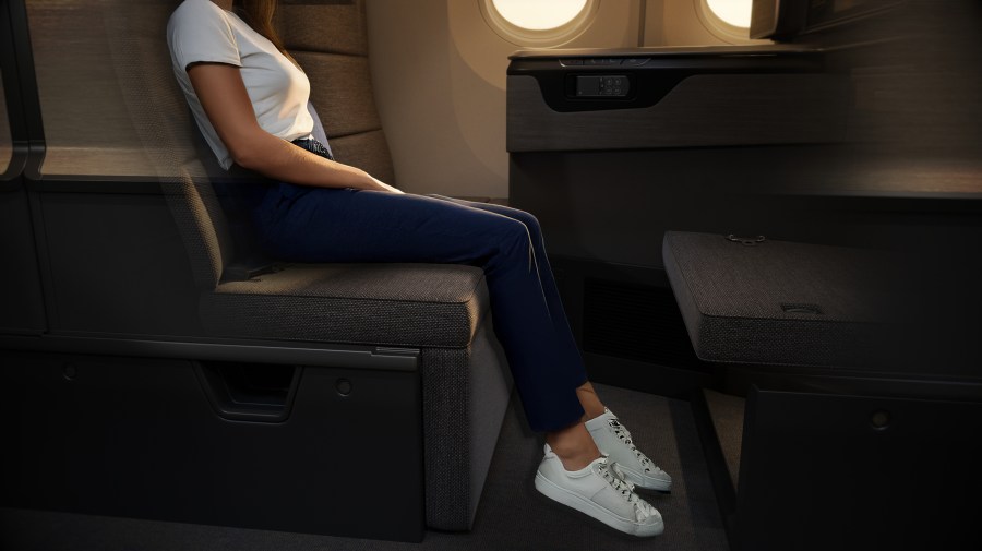 A passenger seated in the new ANA THE Room FX business-class suite, showcasing a modern and spacious design.